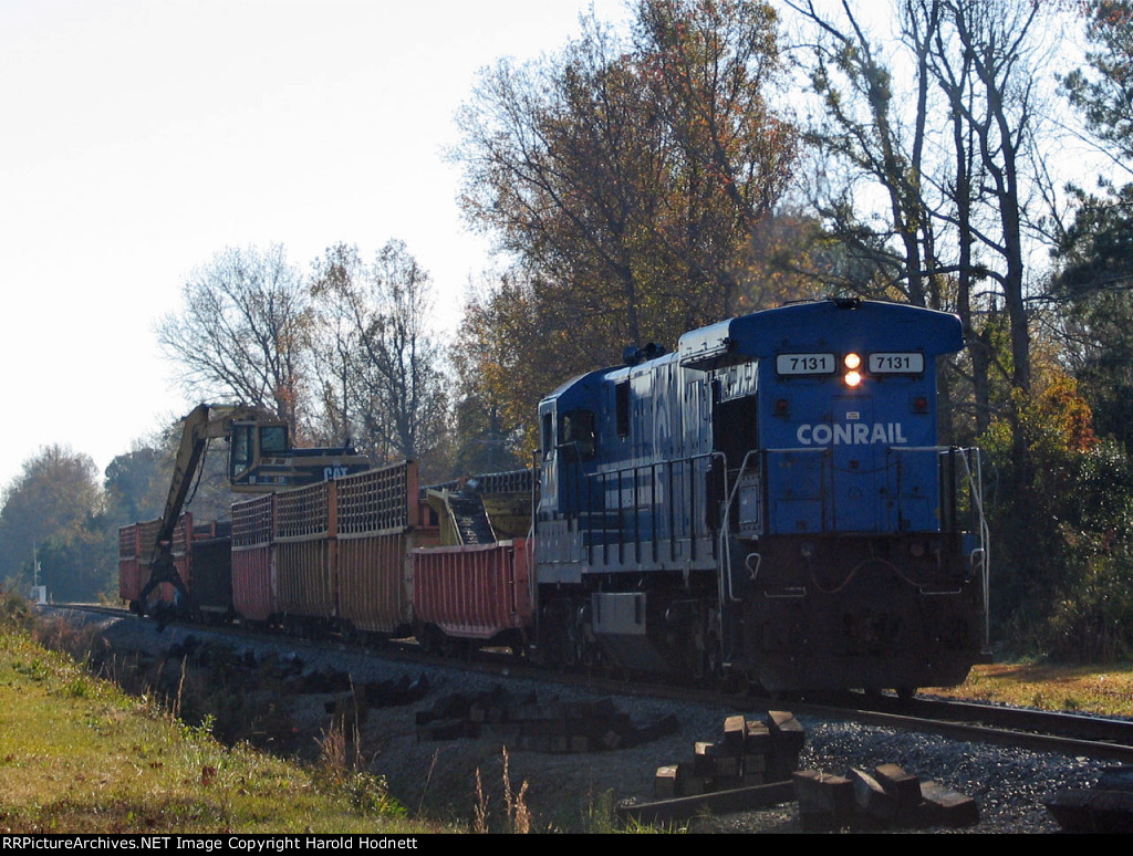CSX 7131 leads a work train slowly along the line